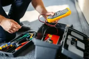Eletricista a inspecionar tomadas queimadas no Porto